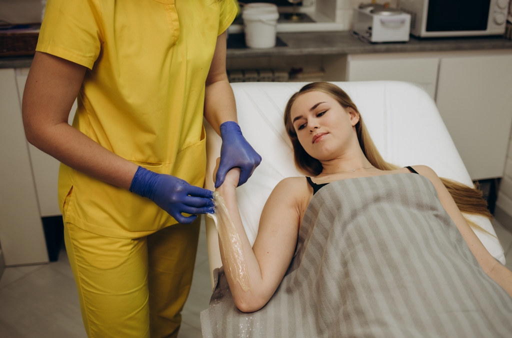 Waxing arms in beauty salon.