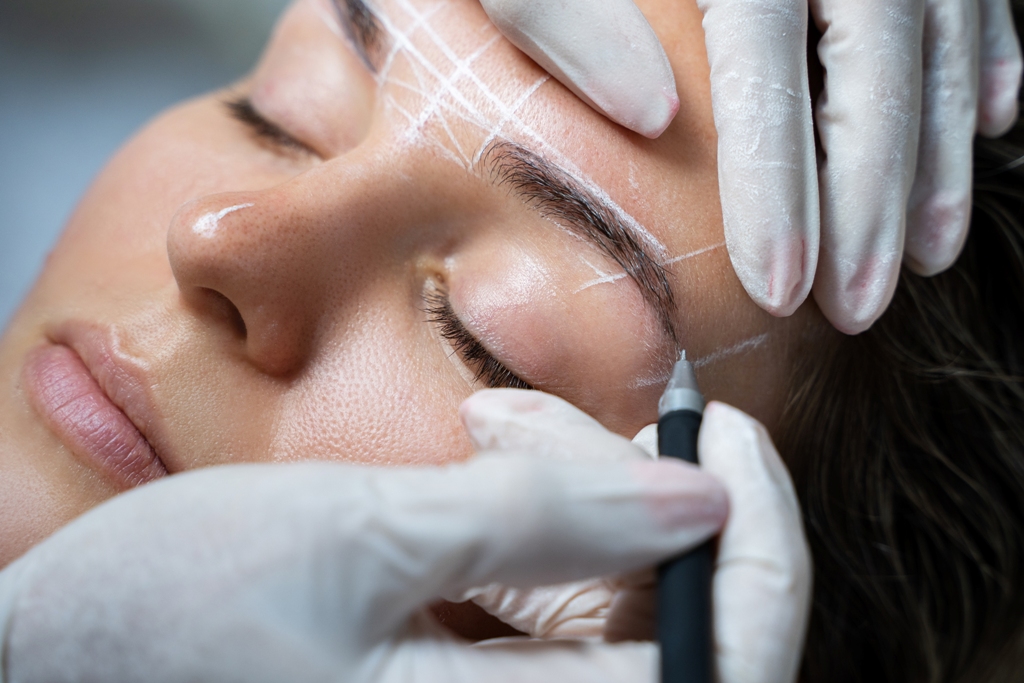 Woman during professional eyebrow mapping procedure